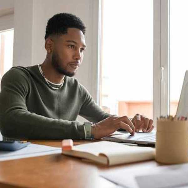 A man at a table working on a computer
