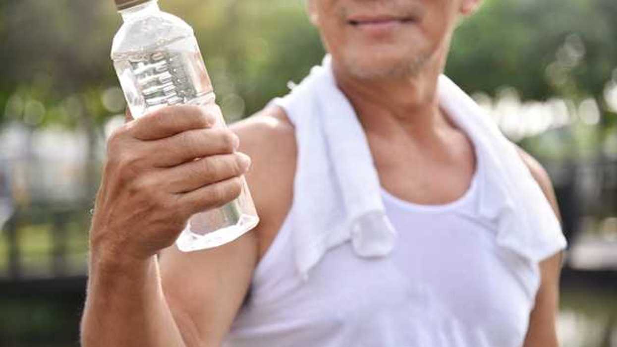 A man holding a plastic bottle filled with water