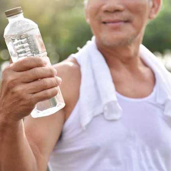 A man holding a plastic bottle filled with water