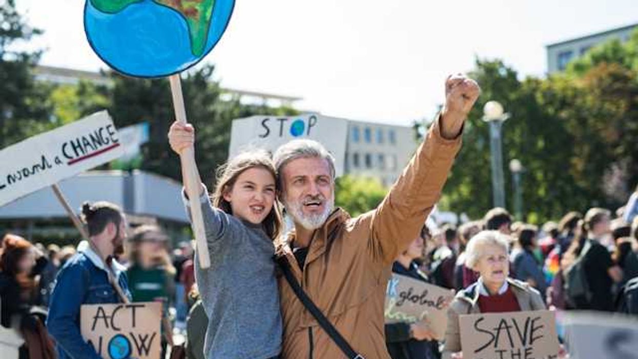 A man holding his daughter during a climate protest