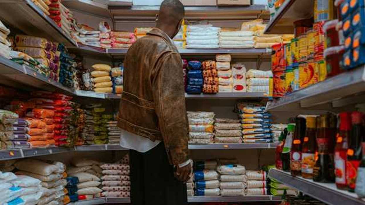 A man looking at a shelf full of food in a grocery store