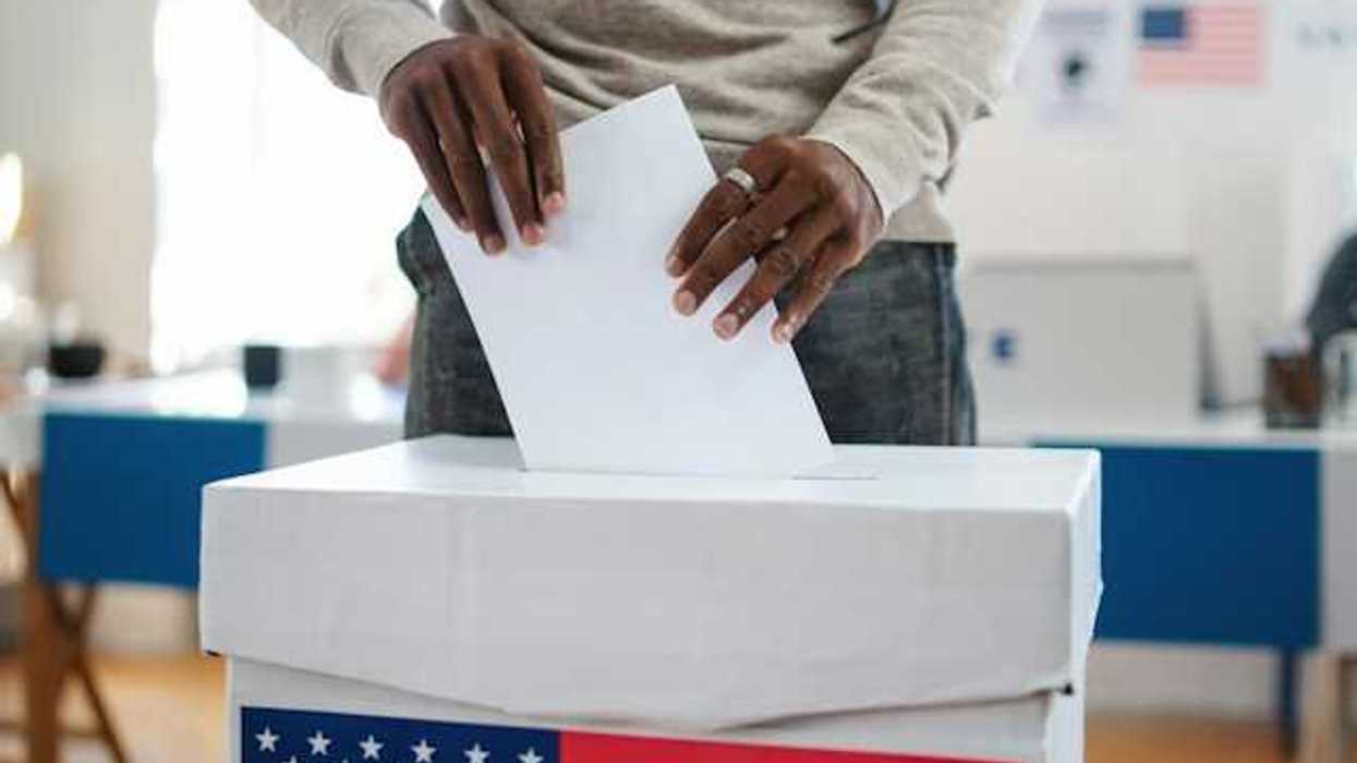 A man putting his vote in a ballot box in the U.S.