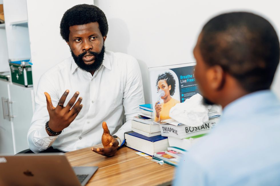 A man sitting at a desk talking to a doctor.