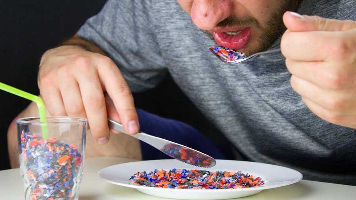 A man sitting at a table eating small pieces of plastic from a plate
