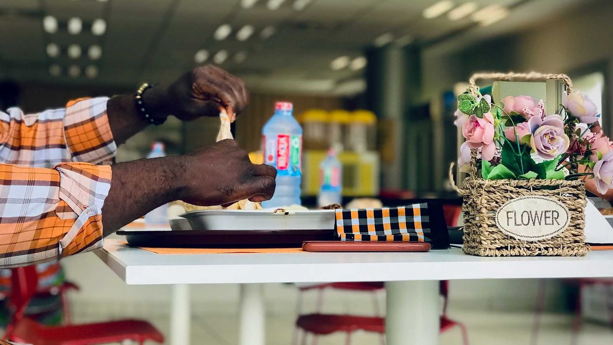 a man sitting at a table in a cafeteria