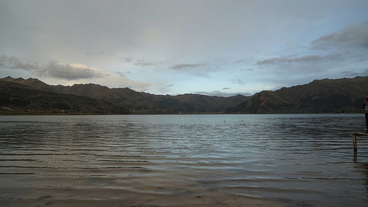 a man standing on a dock in the middle of a lake.