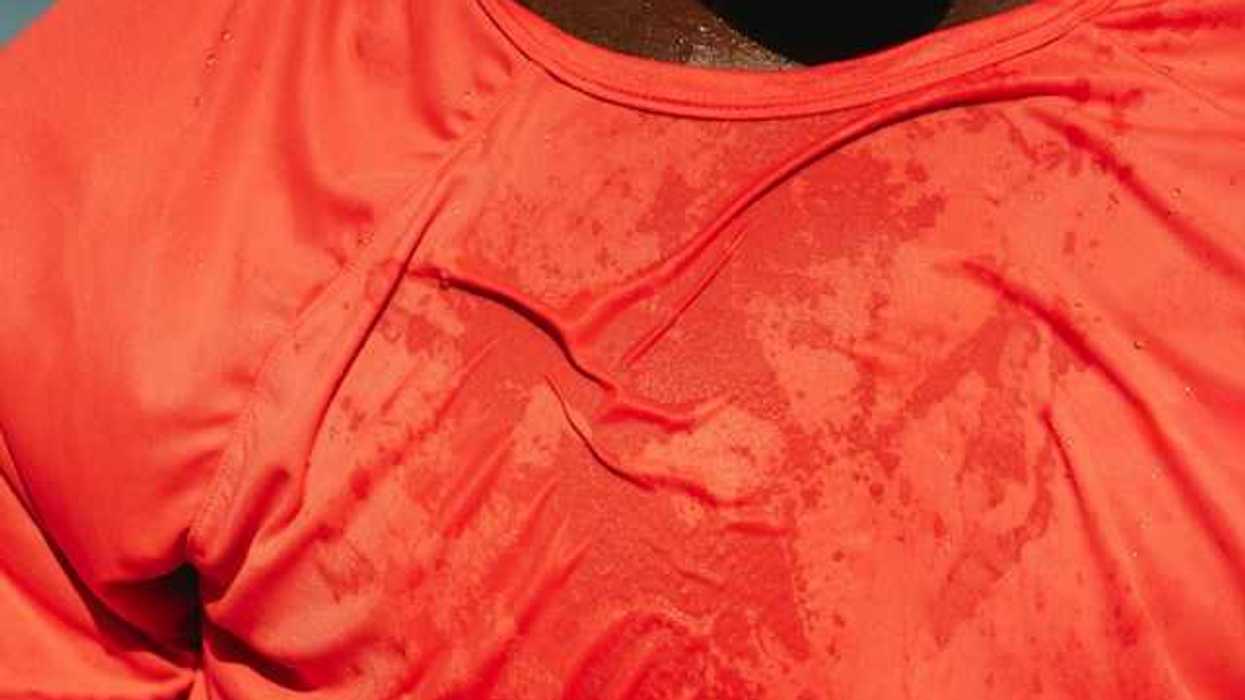 A man wearing a red shirt that appears to be wet