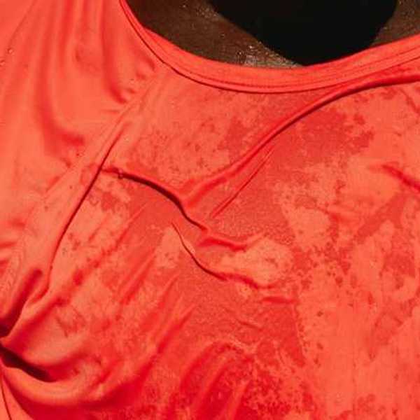 A man wearing a red shirt that appears to be wet