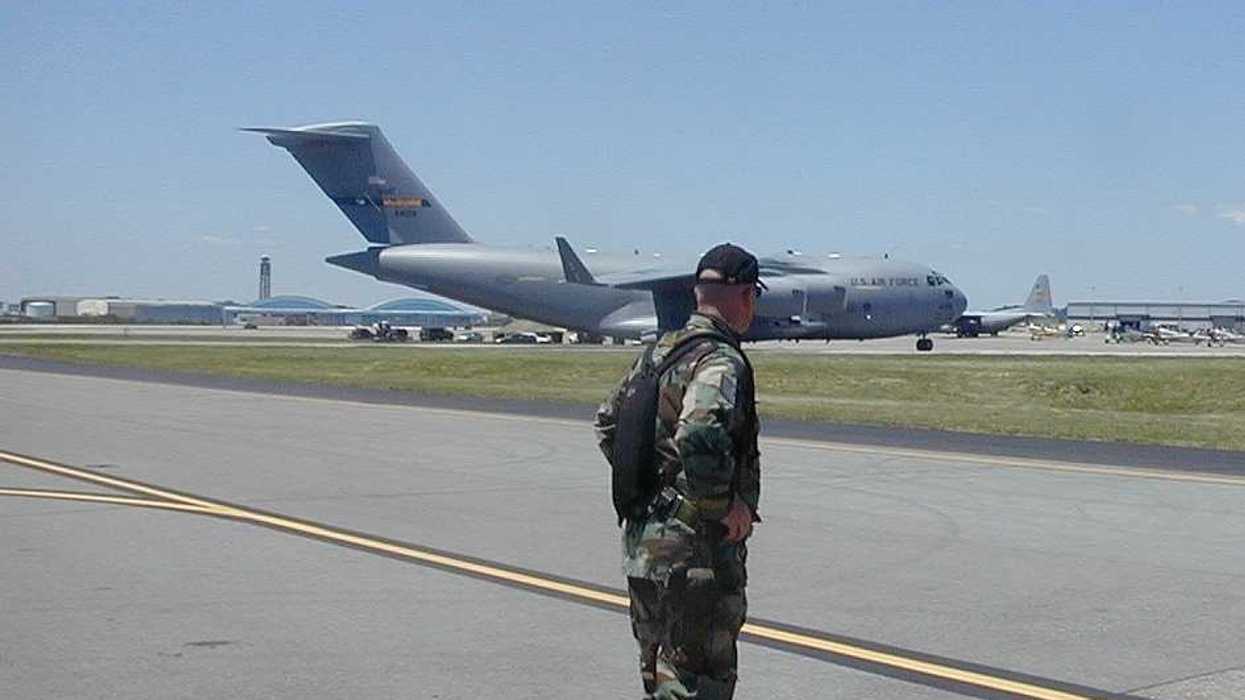A man wearing camo standing on the tarmac in front of an Air Force plane