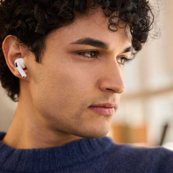 A man wears bluetooth wireless headphones