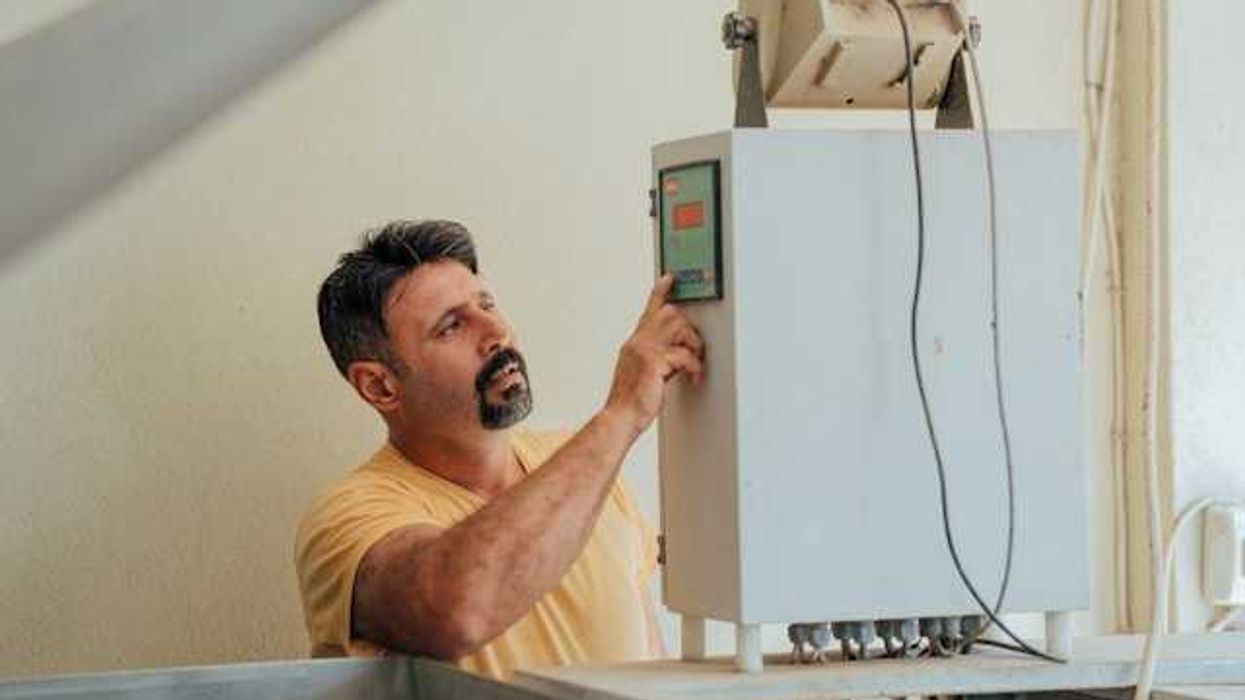 A man working on an installation of a heat pump