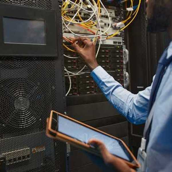 A man working on wires coming out of a server