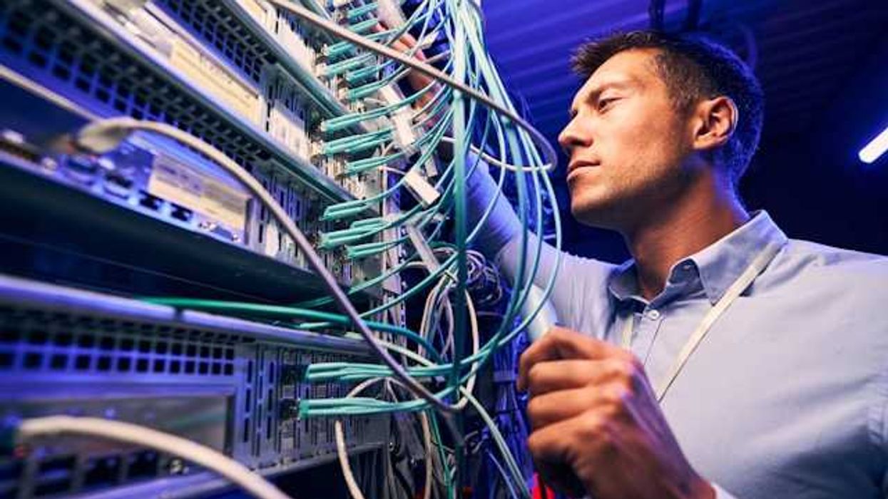A man working on wires on a data server