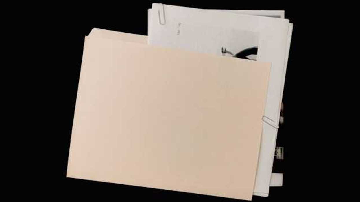 A manila folder covering a pile of documents