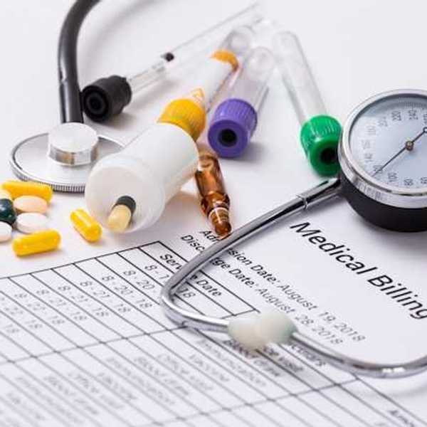 A medical billing statement with a stethoscope and assorted prescription pills next to it