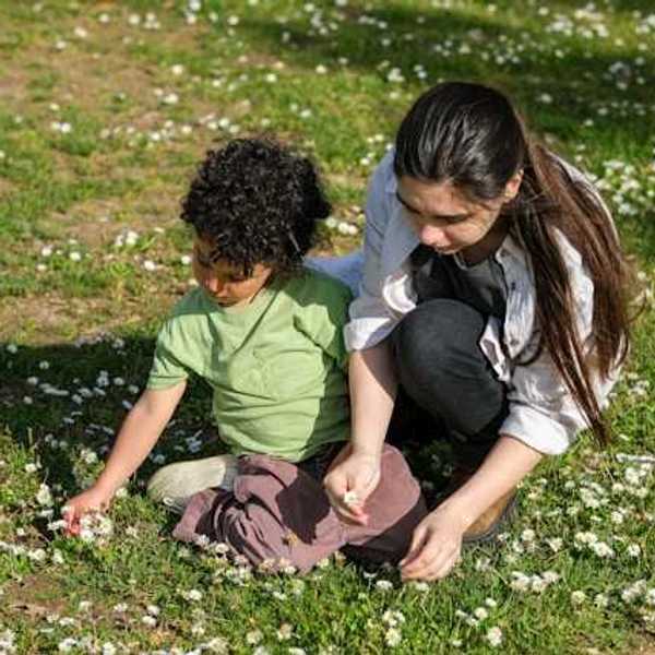 A mother and her son picking wildflowers in a field