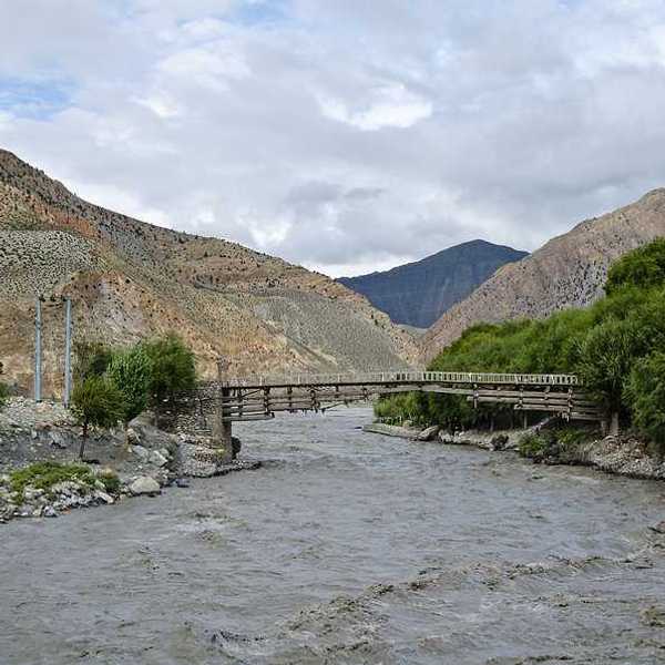 A muddy rising river in a valley in Nepal