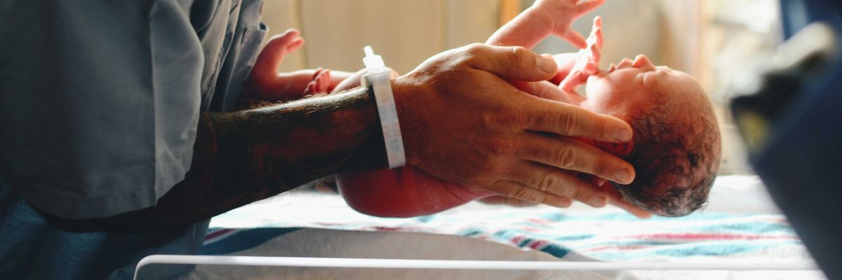 A newborn infant is weighed on a scale