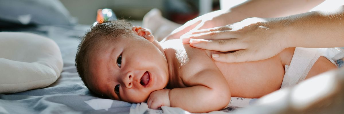 A newborn lays on a bed