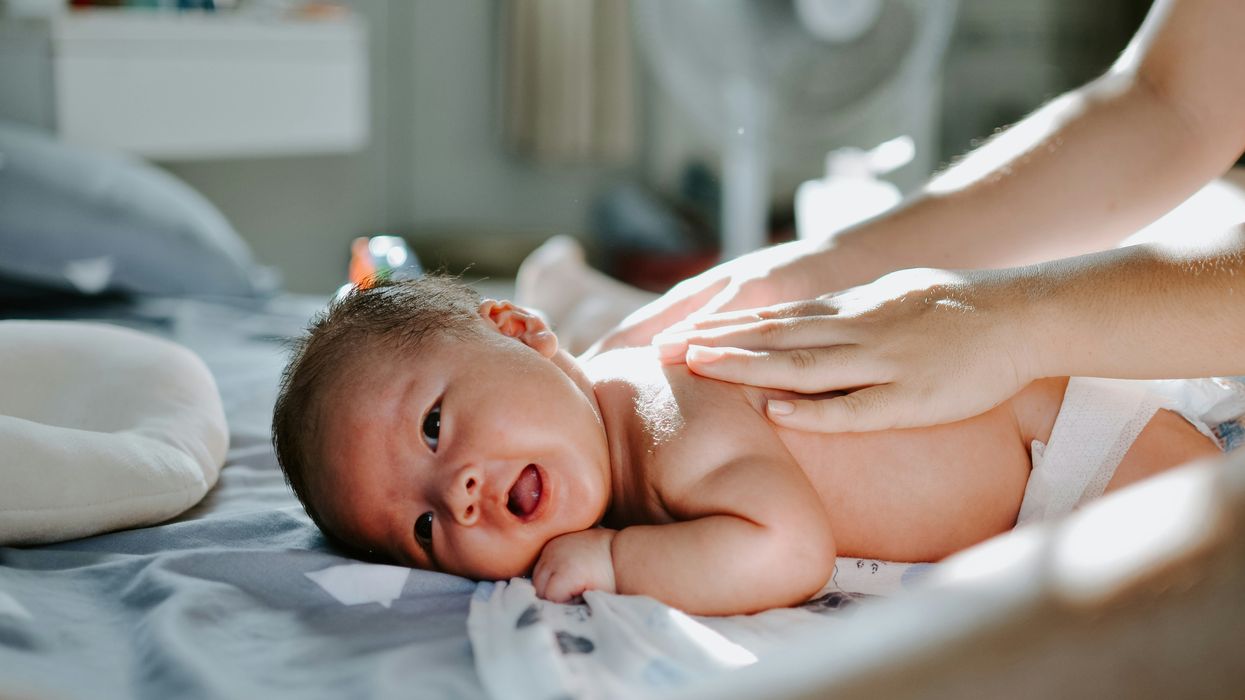 A newborn lays on a bed