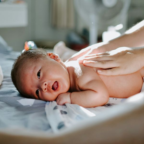 A newborn lays on a bed