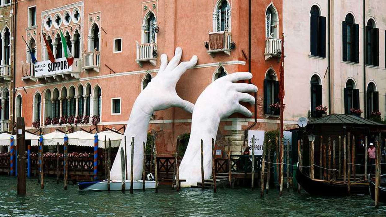 A pair of giant hands rising out of a Venice canal to hold up a building