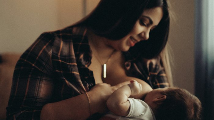 a person breastfeeding a baby