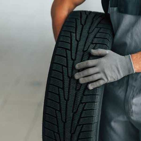 A person holding a car tire
