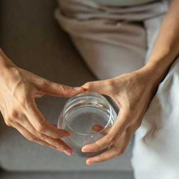 A person holding a glass of water