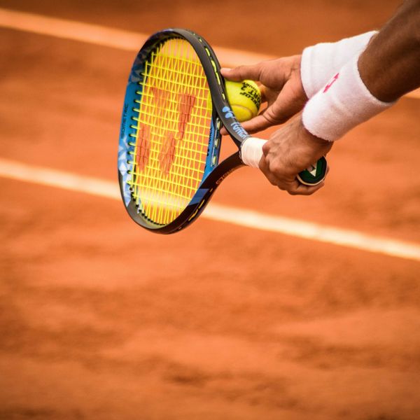 a person holding a tennis racket on a tennis court