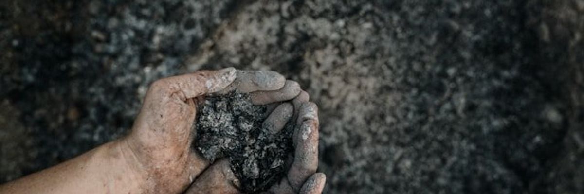 A person holding coal ash in their hands
