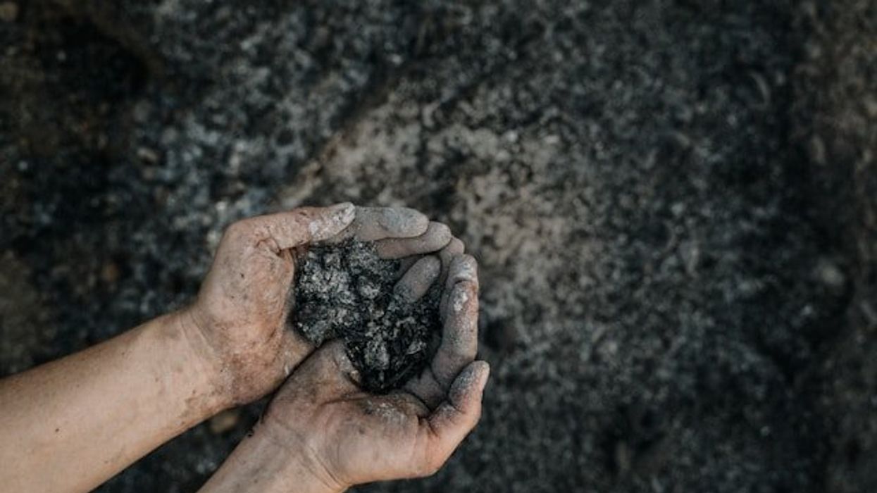 A person holding coal ash in their hands