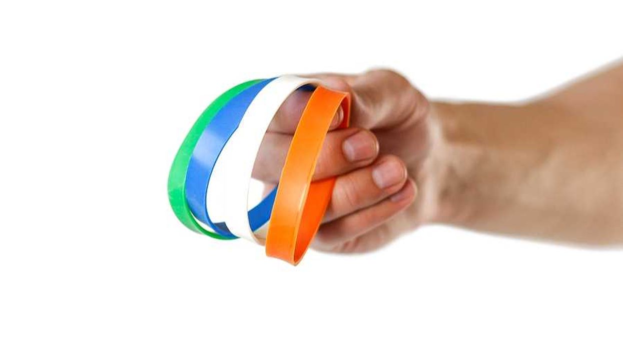 A person holding multicolored silicone wristbands