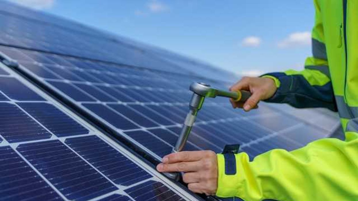 A person installing solar panels on a rooftop