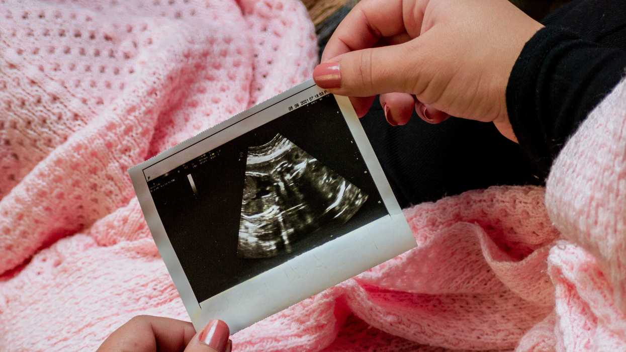 a person is holding a picture of a baby.