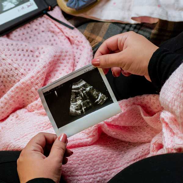 a person is holding a picture of a baby.