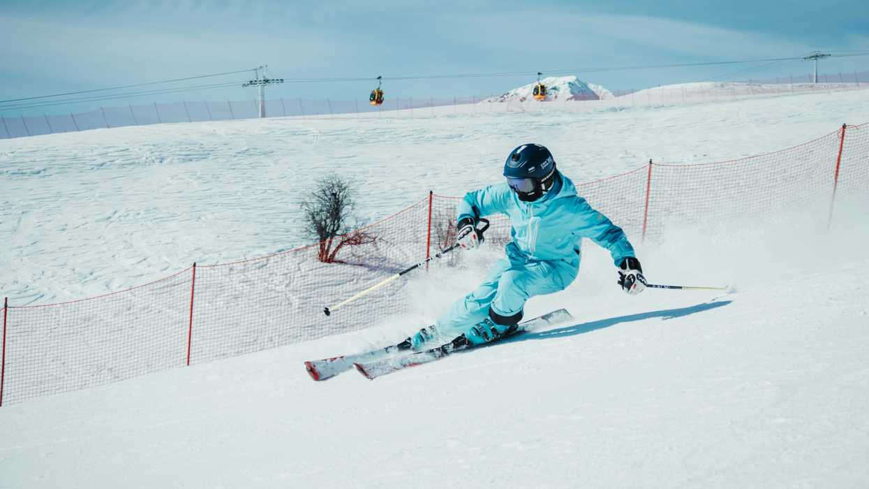 a person on skis going down a snowy hill.