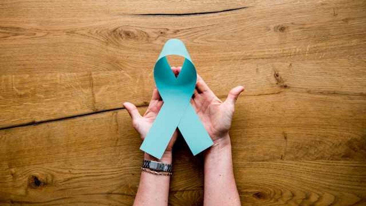 A person's hands holding a light blue ribbon