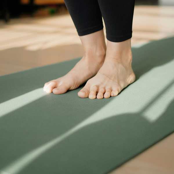 a person standing on a yoga mat on the floor.