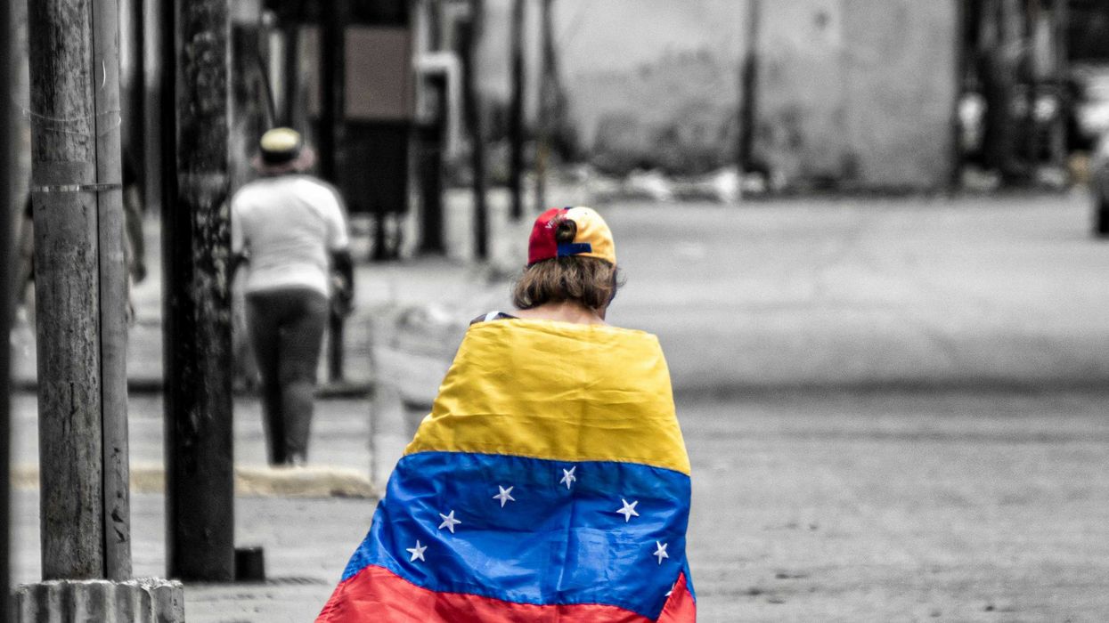A person walking down a street holding a flag.