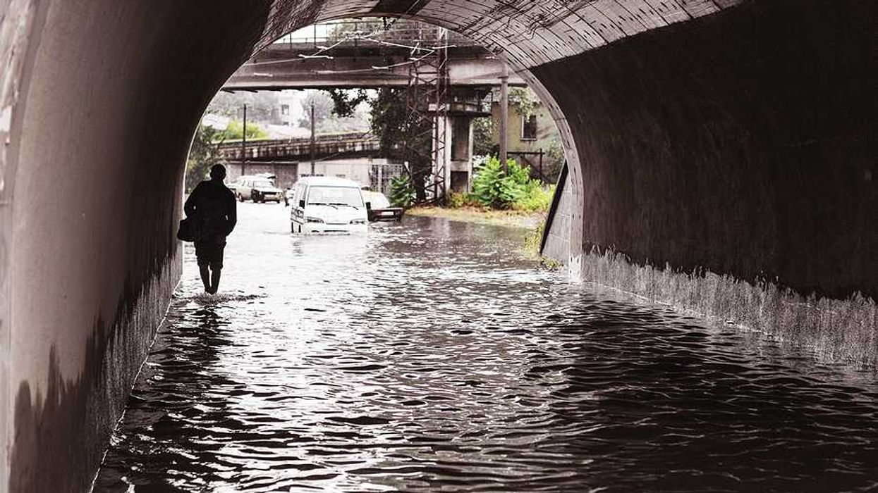 A person walking through a flooded underpass