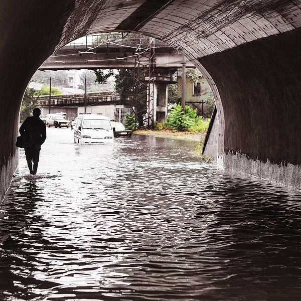 A person walking through a flooded underpass