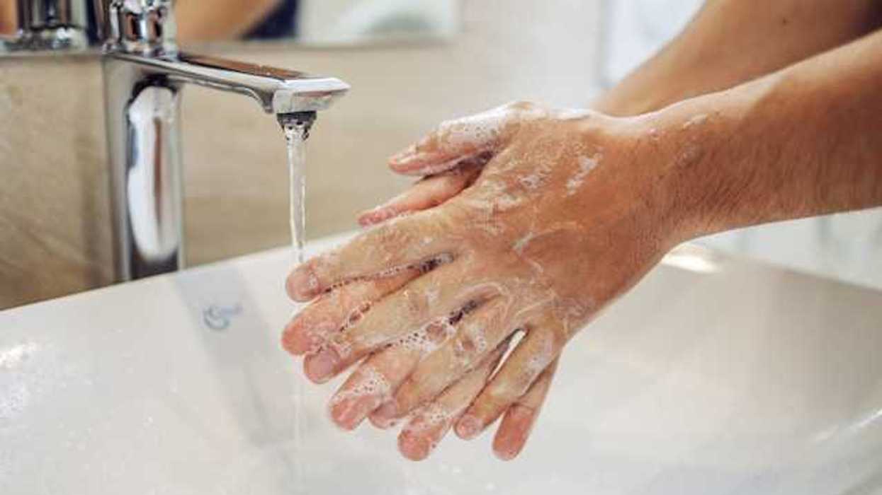 A person washing their hands at a sink