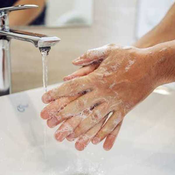 A person washing their hands at a sink