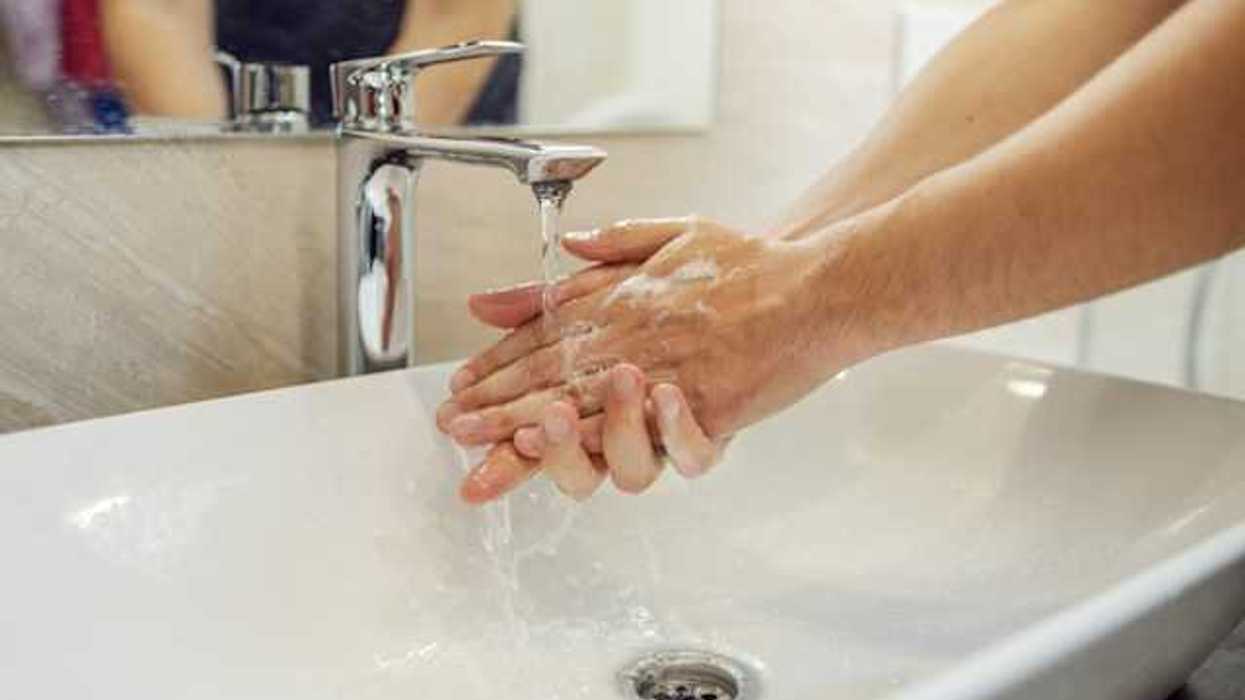 A person washing their hands at a sink