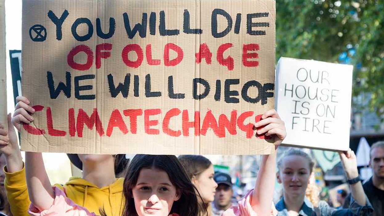 A person with a sign saying 'You will die of old age; we will die of climate change'