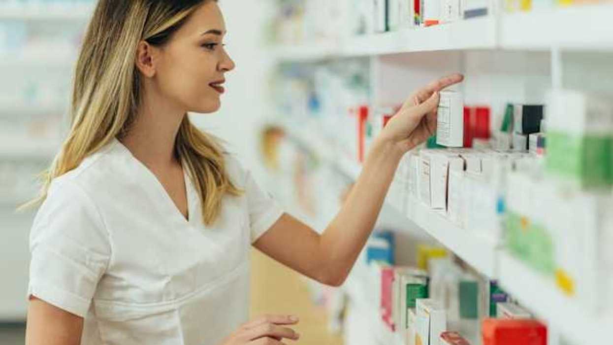 A pharmacist looking at products on a shelf