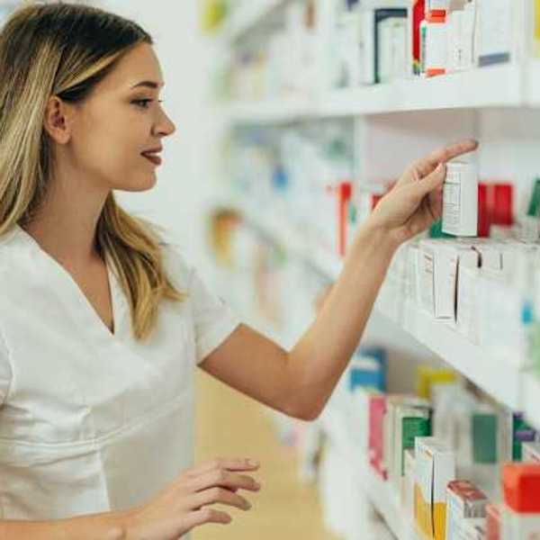 A pharmacist looking at products on a shelf