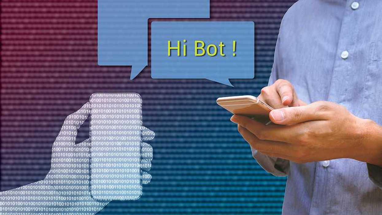 A photo of a person texting on his phone with an image of comment bubbles with the words 'Hi Bot!'