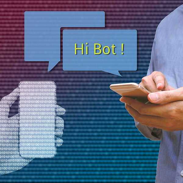 A photo of a person texting on his phone with an image of comment bubbles with the words 'Hi Bot!'